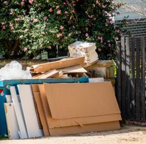 Haushaltsauflösung Sperrmüll und Kartons vor einem Haus – Haushaltsauflösung