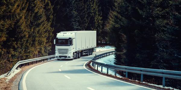 Klaviertransport Kaiserslautern: Lkw fährt auf einer kurvigen Straße durch den Wald