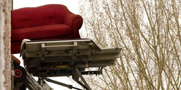 Möbelaufzug: Rotes Sofa auf der Plattform eines Möbellifts