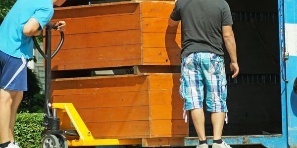 Möbellift Kaiserslautern: Zwei Helfer tragen einen Holzschrank aus einem Lkw